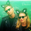 Jeff and Britta from Community wearing black leather jackets, sunglasses, and black cat ears